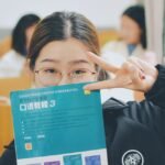 Adolescente sonriendo con libro de inglés en clase en Puebla